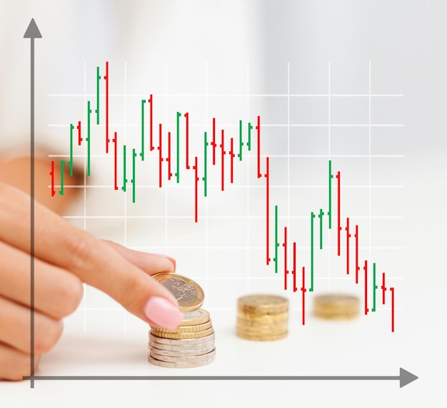 비즈니스, 재정, 위기, 사람, 그리고 돈 절약 개념 - 그래프와 여성의 손이 사무실의 기둥에 유로 동전을 넣는 것을 닫습니다.