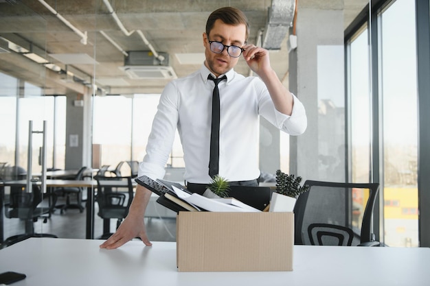 Foto il licenziamento aziendale e il concetto di perdita del lavoro hanno licenziato un impiegato maschio con una scatola delle sue cose personali