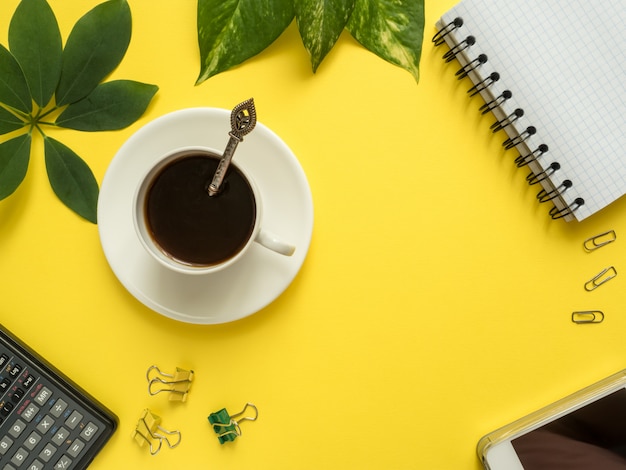 Business flat lay with copy space, calculator, pencil, Notepad, coffee on colorful yellow background