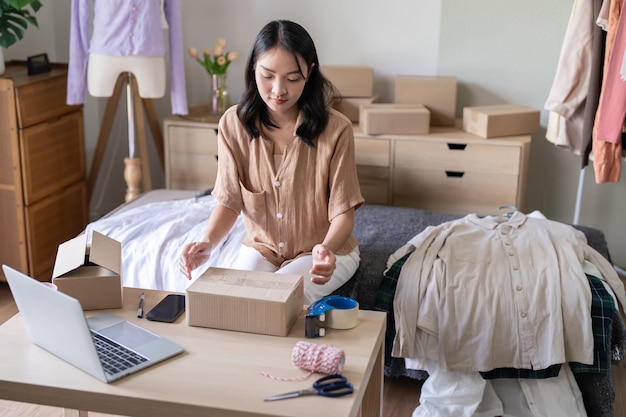 Business From Home Aziatische vrouw die pakketbezorgdoos voorbereidt Verzending om online te winkelen jonge startende eigenaar van een klein bedrijf thuis online bestellen