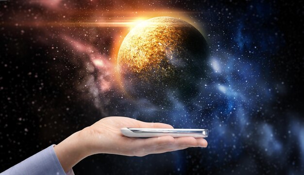 未来のテクノロジーと人間のビジネスコンセプト スマートフォンを握る女性の手 宇宙の背景の惑星