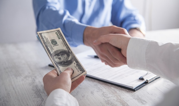 Business girl gives a bribe to employee in the office. Corruption, Bribe