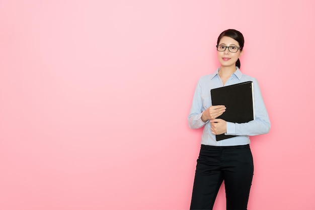 business girl standing on pink background holding a file document