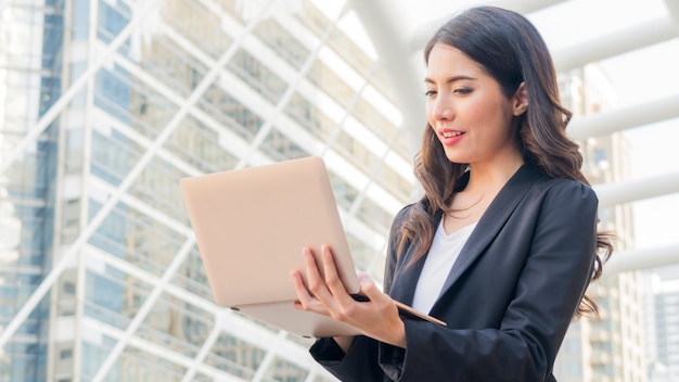 business girl with computer notebook and city background