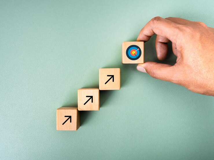 Business goal growth process new objective investment plan economic improvement concepts Hand put target icon on top of wooden cube blocks with rising arrow on green background minimal style