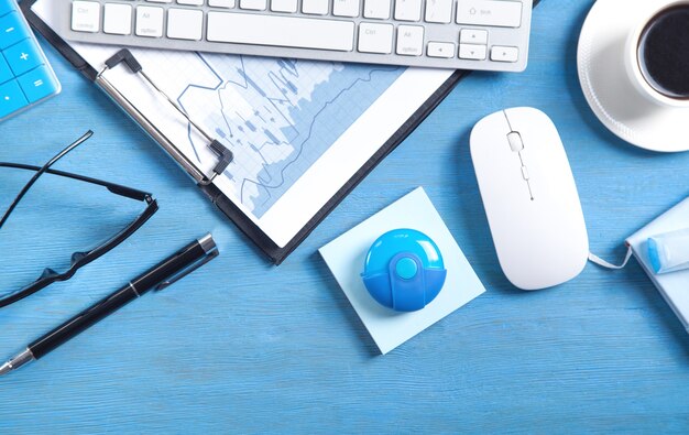 Business graphs, computer keyboard, mouse, coffee, pen and eyeglasses