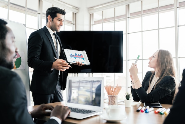 Business group meetings and corporate discussion about last year's review and a new business plan in the office. Businesspeople of various nationalities such as Caucasian and African people in seminar