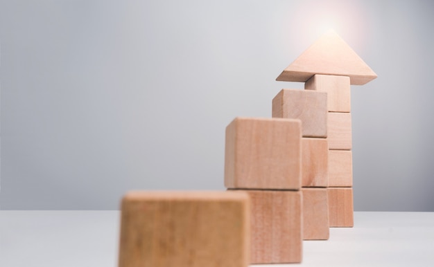 Business growth success concept. Wooden blocks stacking as an arrow up averages as a growth graph chart on white background with copy space, minimal and eco style.