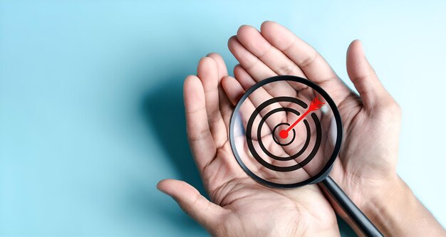 Business hands holding target icon on magnifier dartboard and arrow for creative and set up business objective target goal marketing solution target for business investment