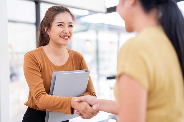 Photo business handshake asian business people making a handshake two corporate businesswoman shaking hands during meeting in office