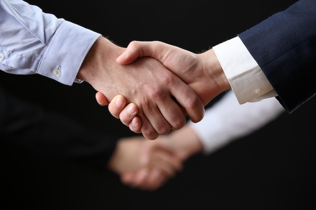 Business handshake on dark background