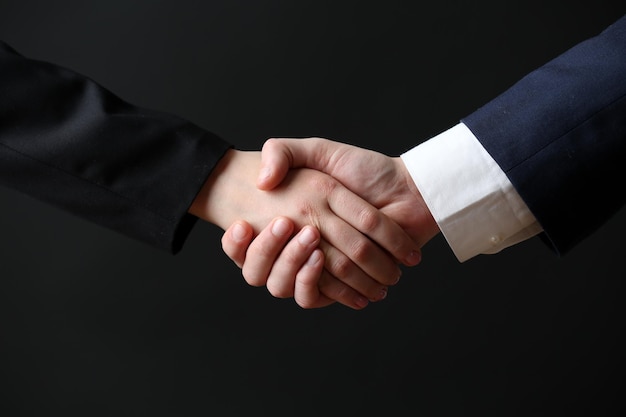 Business handshake on dark background