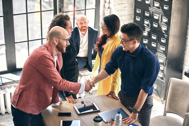 Business handshake at meeting or negotiation in the office. Partners are satisfied because signing contract or financial papers. selective focus.