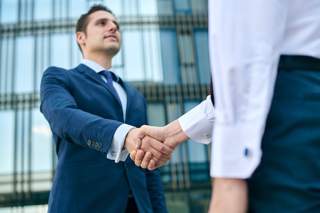 Foto stretta di mano di affari sul fondo del centro dell'ufficio. concetto di incontro di partenariato. handshake di uomini d'affari di successo dopo un buon affare.