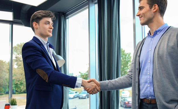 Business handshake Two businessman shaking hands in the office