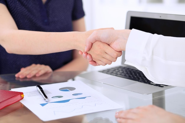 Stretta di mano d'affari due donne si stringono la mano dopo l'incontro o la negoziazione