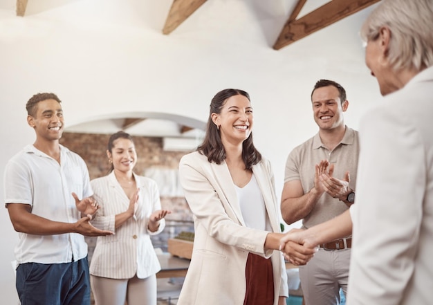 Business handshake with clapping workers in the work office Professional company b2b shaking hands for a deal to come and work together Diverse group of happy staff thank you and welcome employee