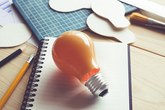 Business ideas with lightbulb on desk table.