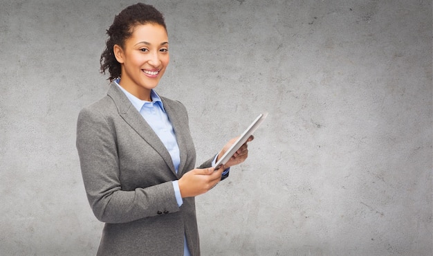 business, internet and technology concept - smiling african-american woman looking at tablet pc computer