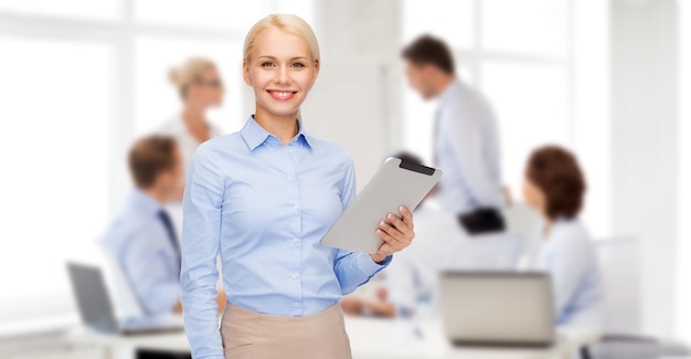 business, internet and technology concept - smiling woman looking at tablet pc computer