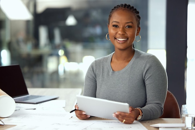 Photo business is good cropped portrait of an attractive young businesswoman using a tablet while sitting in her office