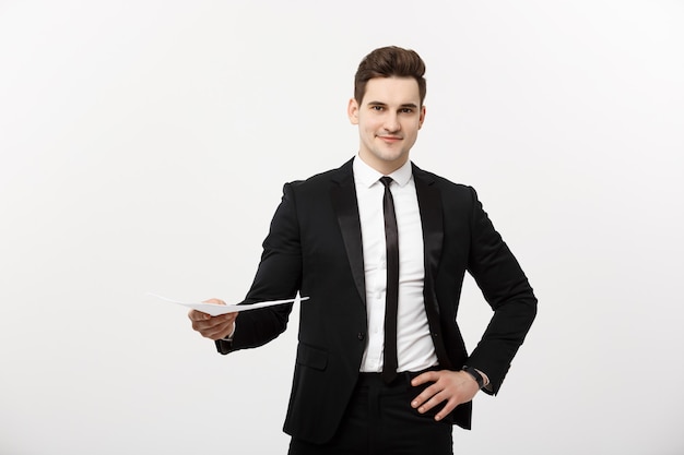 Business and Job Concept: Elegant man in the suit holding resume for job hiring in the bright white interior.