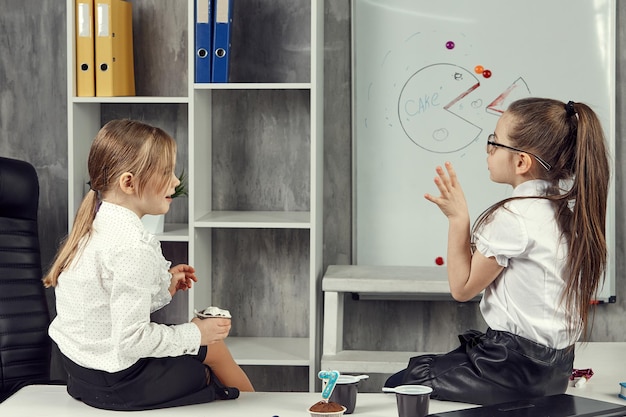 Business kids girls chat while sitting on the table