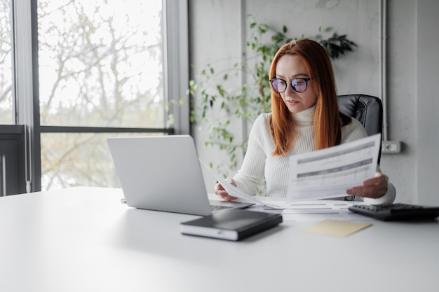 Business lady analyzing documents at her office