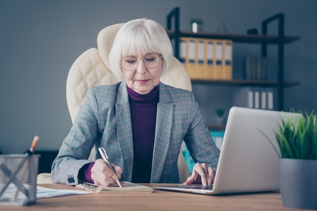 Donna d'affari alla scrivania che lavora sul suo laptop