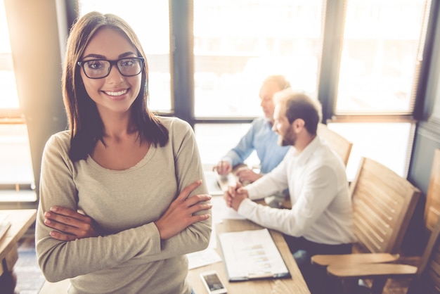 Business lady in eyeglasses is looking at camera and smiling