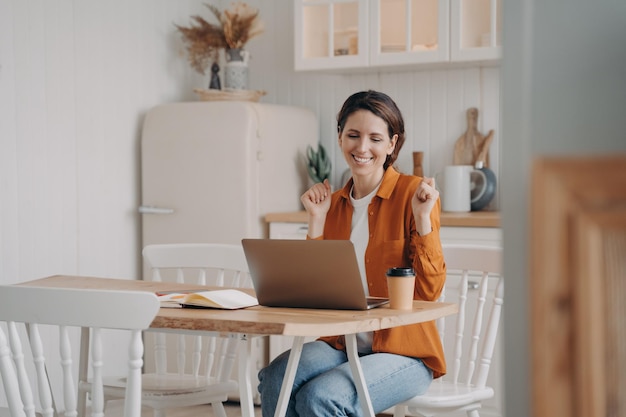 Business lady has online conference Confident woman wins Distance work at kitchen on quarantine