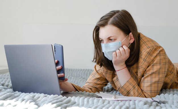 彼女のラップトップと電話で在宅勤務のビジネス女性