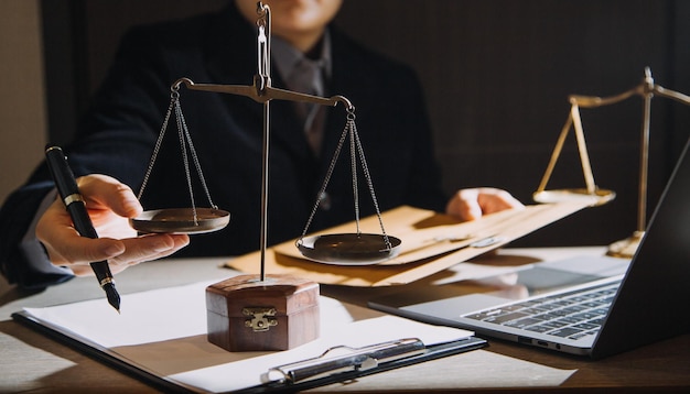 Business and lawyers discussing contract papers with brass
scale on desk in office law legal services advice justice and law
concept picture with film grain effect