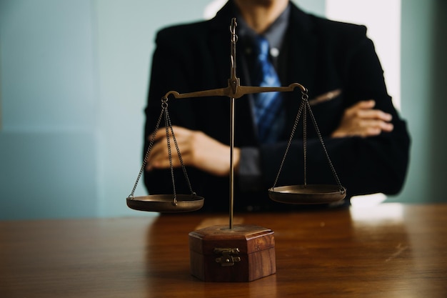 Business and lawyers discussing contract papers with brass scale on desk in office Law legal services advice justice and law concept picture with film grain effect