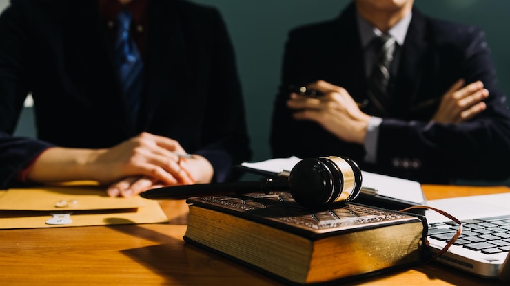 Photo オフィスの机の上で真ちゅう製の目盛り付きの契約書について話し合うビジネスと弁護士