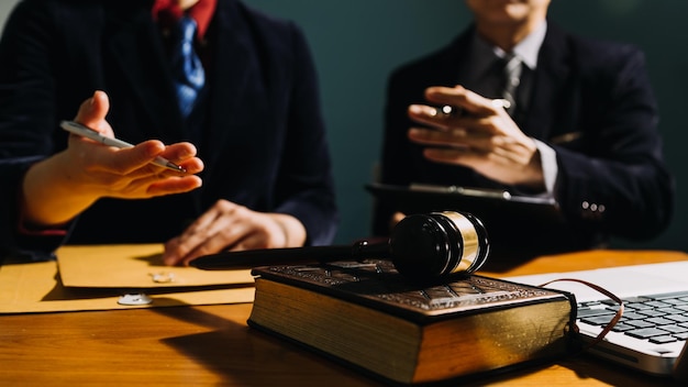 Business and lawyers discussing contract papers with brass scale on desk in office Law legal services advice justice and law concept picture with film grain effect