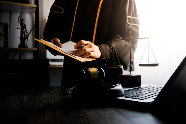 Business and lawyers discussing contract papers with brass scale on desk in office Law legal services advice justice and law concept picture with film grain effect