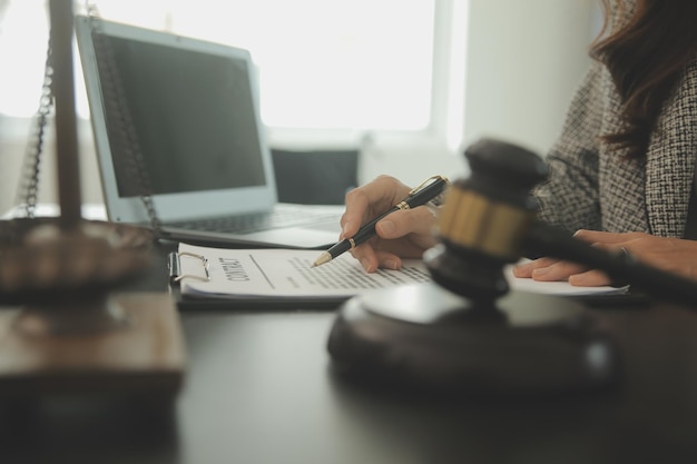 Business and lawyers discussing contract papers with brass scale on desk in office Law legal services advice justice and law concept picture with film grain effect