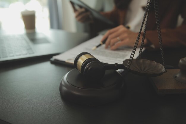 Business and lawyers discussing contract papers with brass scale on desk in office Law legal services advice justice and law concept picture with film grain effect