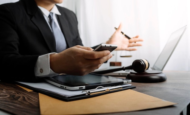 Business and lawyers discussing contract papers with brass scale on desk in office Law legal services advice justice and law concept picture with film grain effect