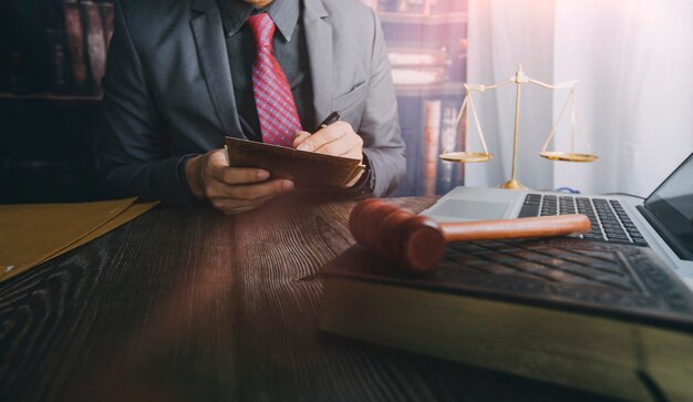 business and lawyers discussing contract papers with brass scale on desk in office law legal services advice justice and law concept picture with film grain effect
