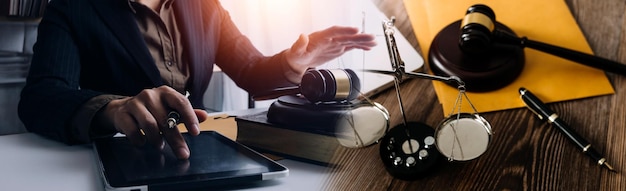 Business and lawyers discussing contract papers with brass scale on desk in office Law legal services advice justice and law concept picture with film grain effect