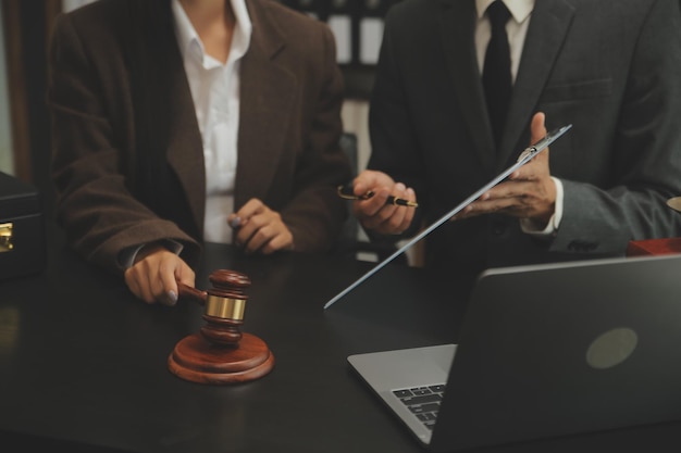 Business and lawyers discussing contract papers with brass scale on desk in office Law legal services advice justice and law concept picture with film grain effect