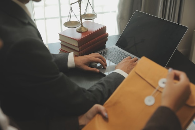 Business and lawyers discussing contract papers with brass scale on desk in office Law legal services advice justice and law concept picture with film grain effect