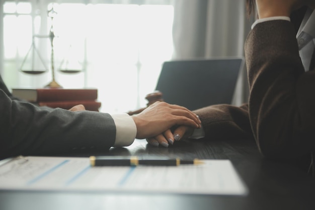 Business and lawyers discussing contract papers with brass scale on desk in office Law legal services advice justice and law concept picture with film grain effect