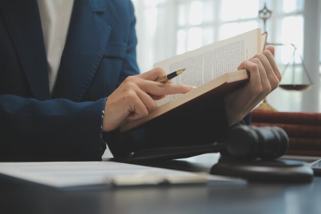 Business and lawyers discussing contract papers with brass scale on desk in office Law legal services advice justice and law concept picture with film grain effect