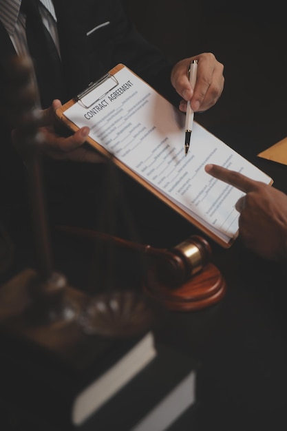 Business and lawyers discussing contract papers with brass scale on desk in office Law legal services advice justice and law concept picture with film grain effect