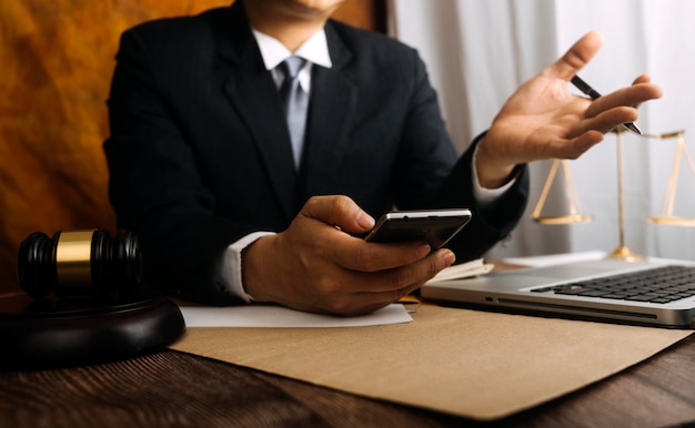 Business and lawyers discussing contract papers with brass scale on desk in office Law legal services advice justice and law concept picture with film grain effect