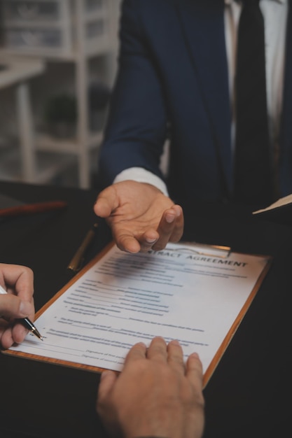 Business and lawyers discussing contract papers with brass scale on desk in office Law legal services advice justice and law concept picture with film grain effect