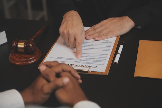 Business and lawyers discussing contract papers with brass scale on desk in office Law legal services advice justice and law concept picture with film grain effect